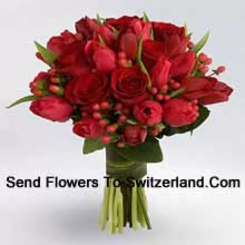 Gros bouquet de roses rouges et de tulipes rouges avec des garnitures de saison rouges.